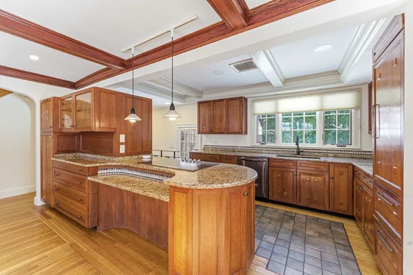 a kitchen with stainless steel appliances granite countertop a sink a stove and a wooden floors