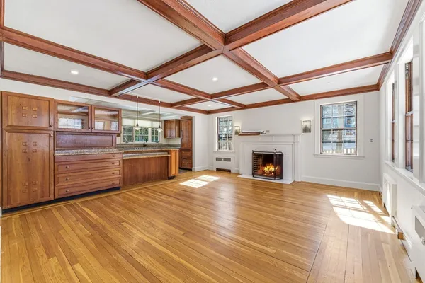 a view of a livingroom with a fireplace a ceiling fan and windows