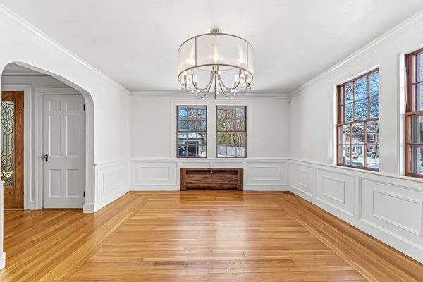 wooden floor with chandelier and window