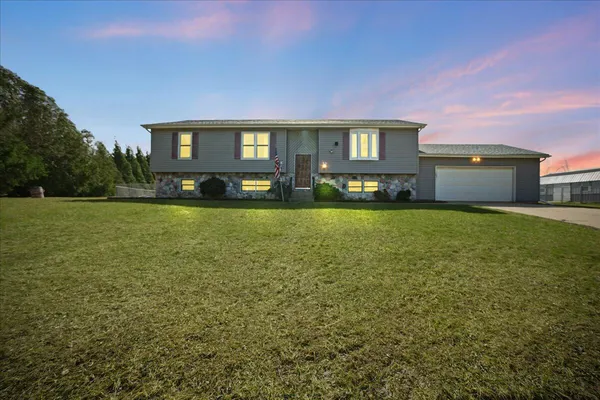 a view of a house with a big yard and a large tree
