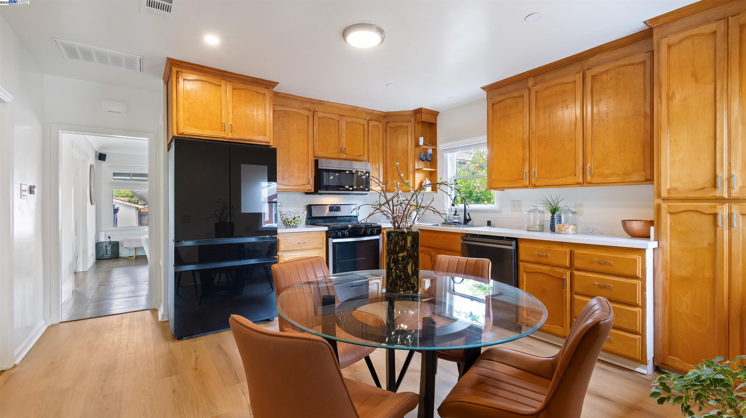 830 Buena Vista Avenue Alameda, CA 94501 - Photo 11 of 28 a kitchen with stainless steel appliances kitchen island granite countertop a refrigerator a stove a sink a dining table and chairs with wooden floor