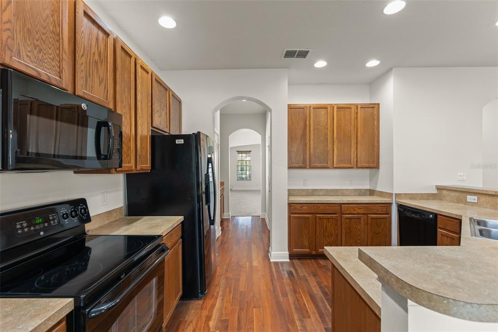 13544 Riggs Way Windermere, FL 34786 - Photo 24 of 58 a kitchen with stainless steel appliances granite countertop a refrigerator a stove top oven a sink dishwasher and wooden cabinets with wooden floor