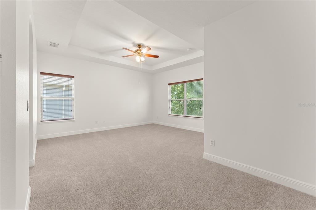 13544 Riggs Way Windermere, FL 34786 - Photo 30 of 58 an empty room with windows and chandelier fan