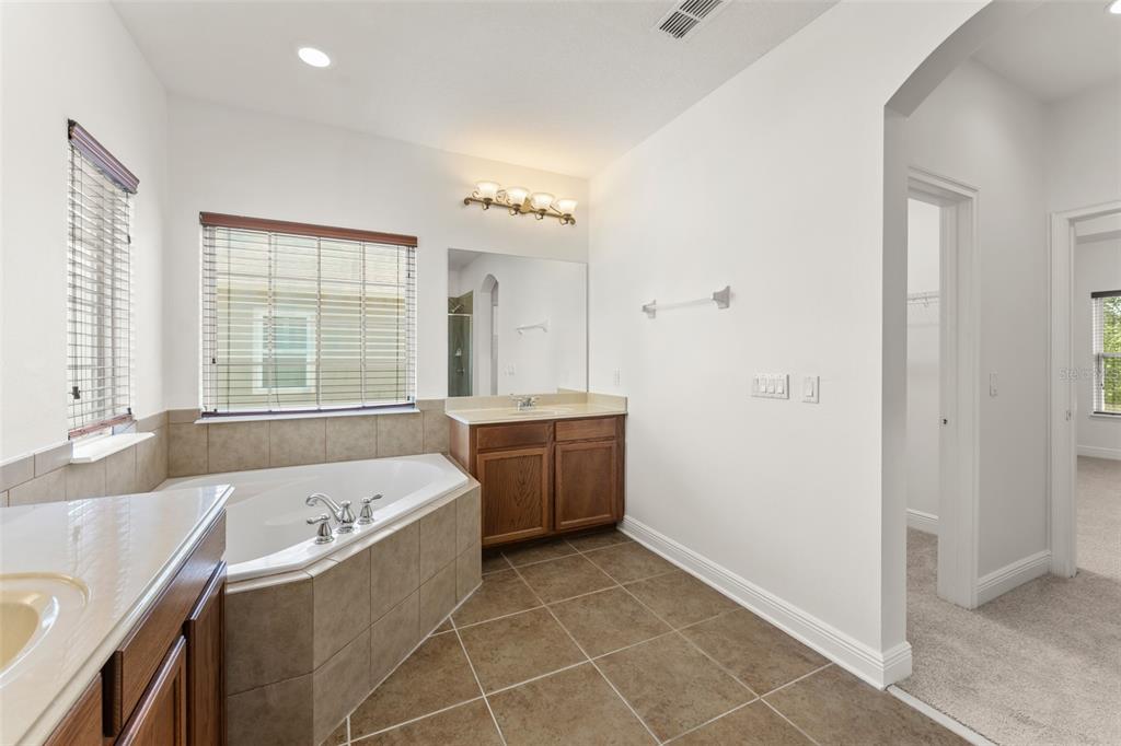 13544 Riggs Way Windermere, FL 34786 - Photo 38 of 58 a bathroom with a tub sink and mirror