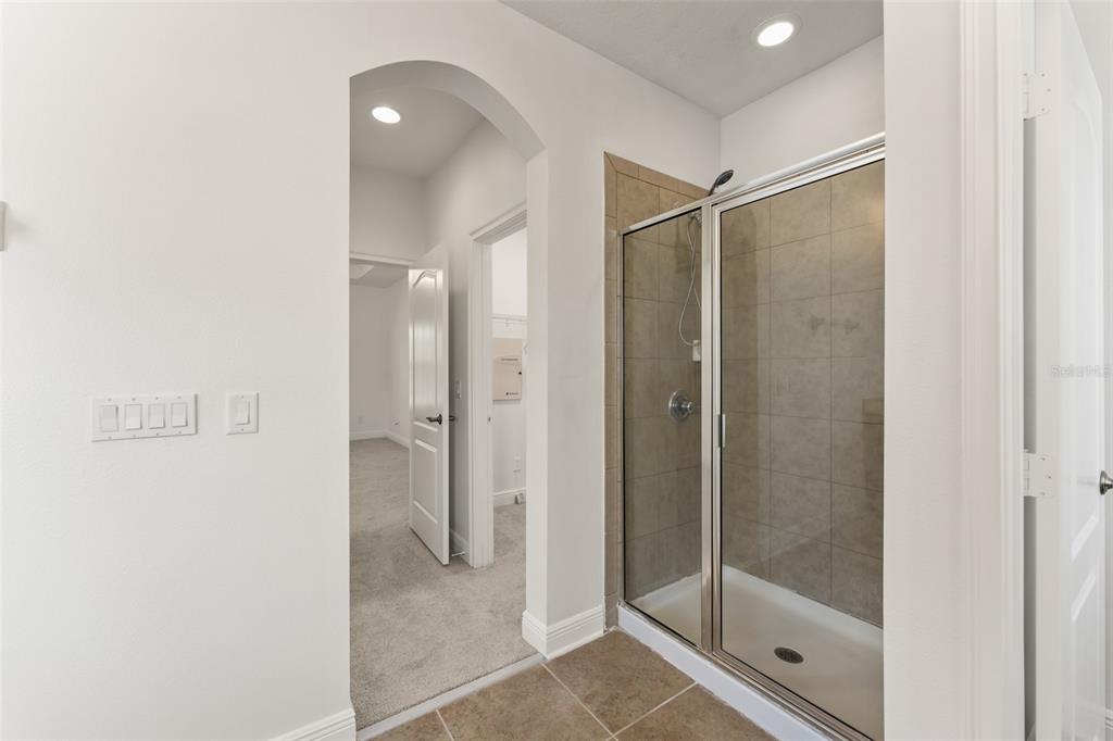 13544 Riggs Way Windermere, FL 34786 - Photo 39 of 58 a bathroom with a glass shower door and a window