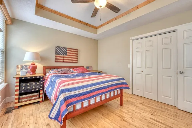 a bedroom with a bed a dresser and a chandelier