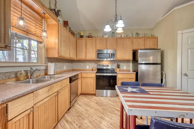 a kitchen with a sink stainless steel appliances and window