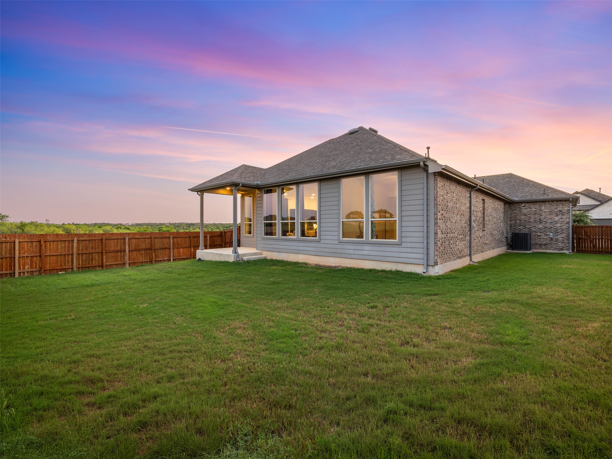 606 Spinnaker Loop Kyle, TX 78640 - Photo 27 of 37 A spacious private yard offers abundant room for outdoor enjoyment beneath a vibrant twilight sky.