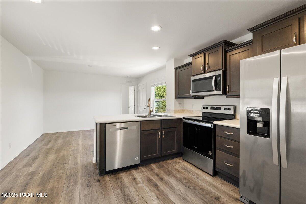 1529 Private Road Prescott, AZ 86301 - Photo 11 of 25 a kitchen with stainless steel appliances granite countertop a refrigerator a stove top oven a sink and dishwasher with wooden floor