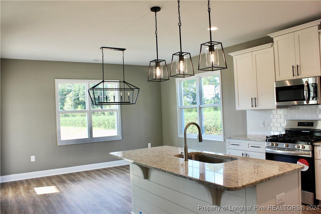6119 Stewart Road Godwin, NC 28344 - Photo 6 of 20 a kitchen with granite countertop a sink stainless steel appliances and a window