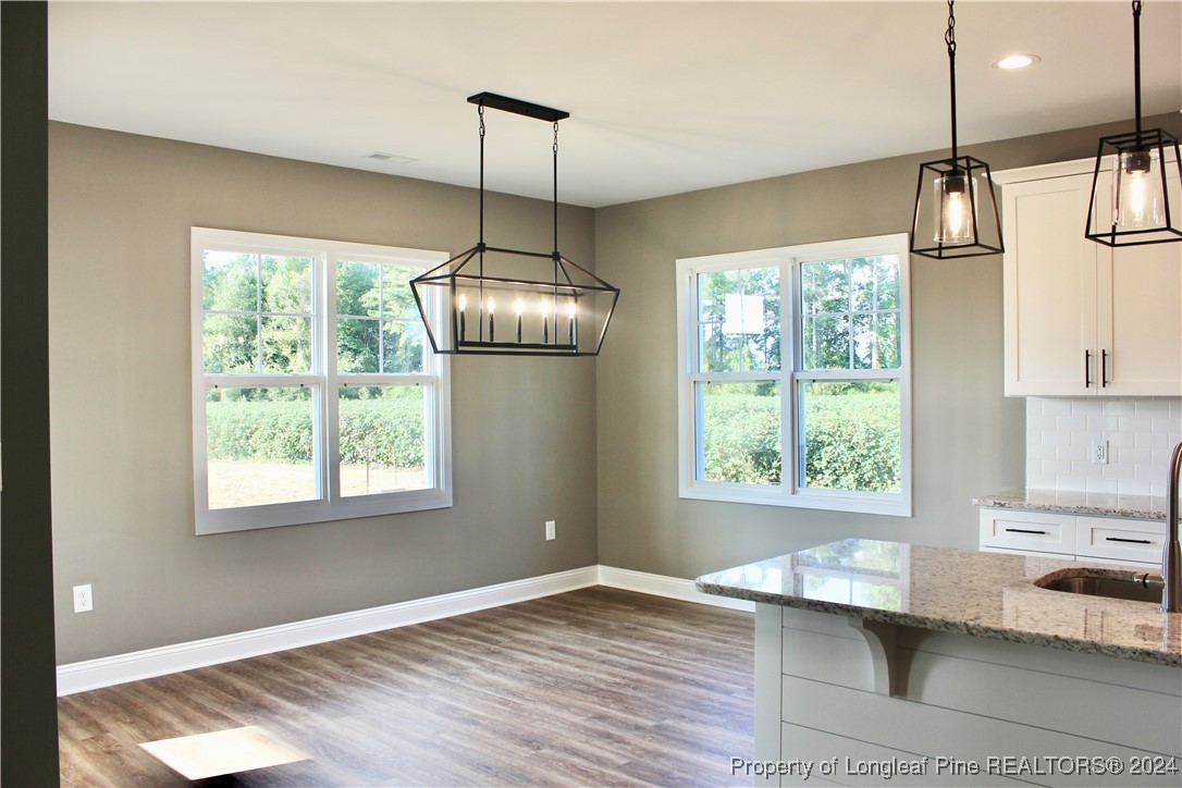 6119 Stewart Road Godwin, NC 28344 - Photo 8 of 20 a view of empty room with wooden floor and fan