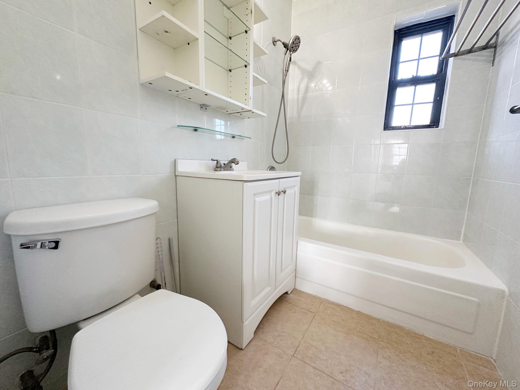 78-16 147th Street, Unit 3C Queens, NY 11367 - Photo 13 of 16 Bathroom featuring shower / washtub combination, vanity, tile walls, and light tile patterned flooring