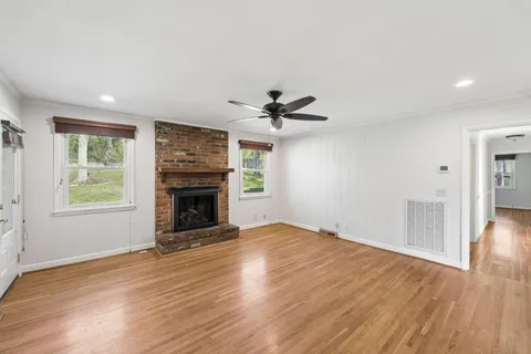 an empty room with windows and a fireplace
