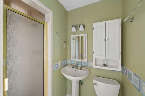 a bathroom with a sink a toilet and shower