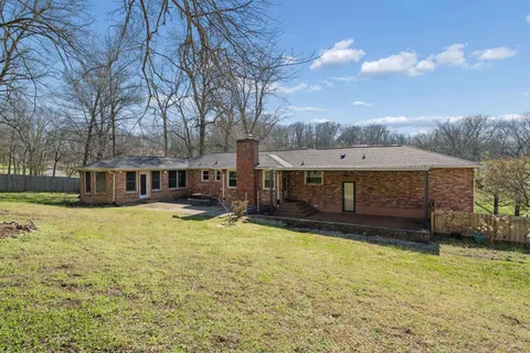 a view of a house with a yard and sitting area