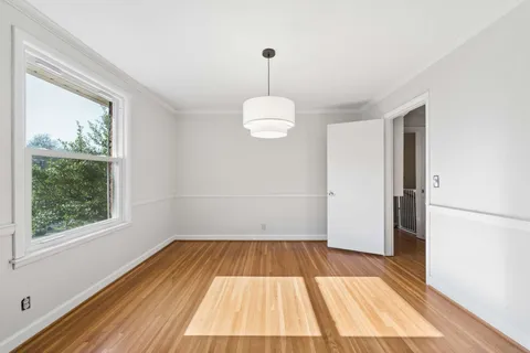 a view of a room with wooden floor fan and window