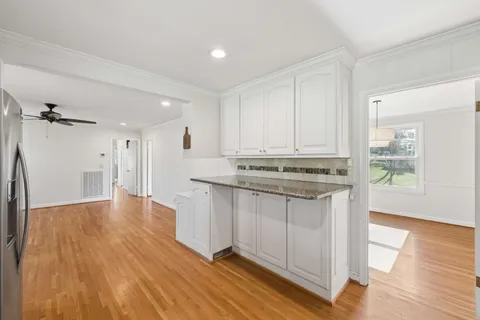 a view of kitchen with stainless steel appliances cabinets and wooden floor