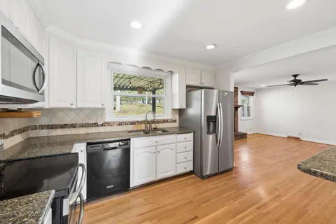a kitchen with stainless steel appliances granite countertop a refrigerator and a stove top oven