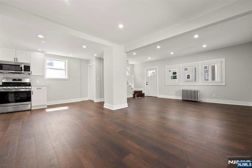 240 Berry Street Hackensack, NJ 07601 - Photo 8 of 25 an empty room with wooden floor and windows