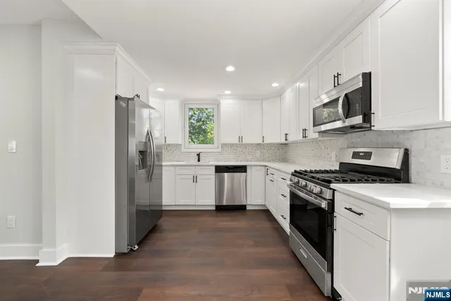a kitchen with stainless steel appliances white cabinets and a sink