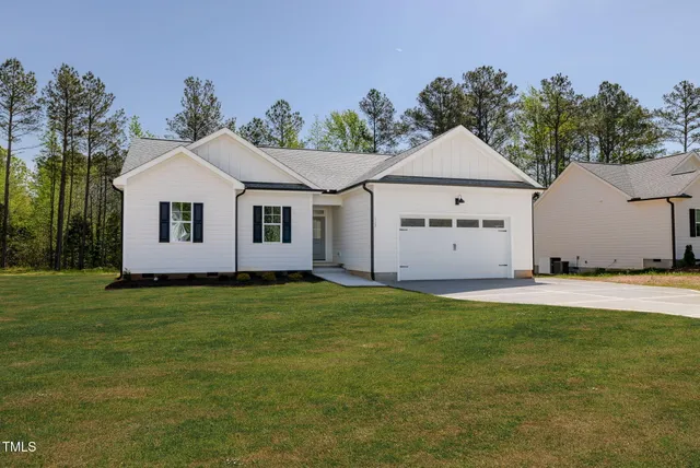 a view of a white house with a yard