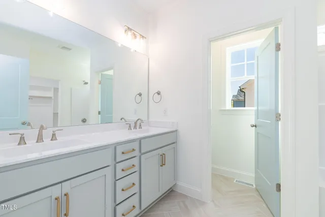 a bathroom with a double vanity sink and mirror