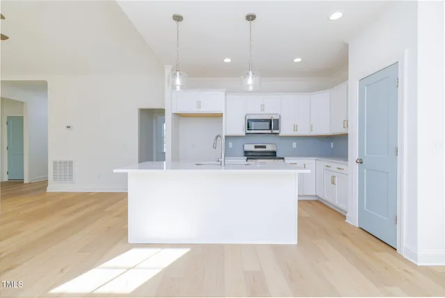 a view of kitchen with kitchen island sink stainless steel appliances and cabinets