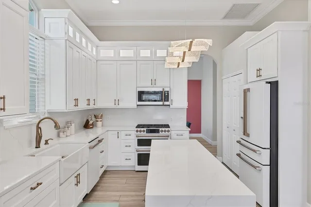 a kitchen with stainless steel appliances granite countertop a sink a stove and a refrigerator