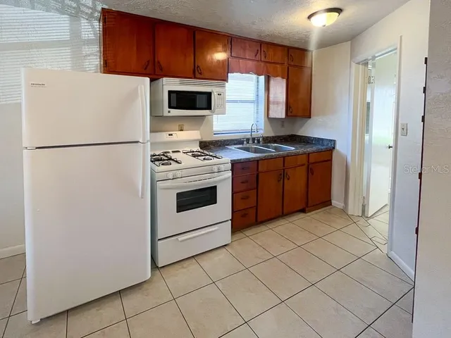 a kitchen with cabinets a refrigerator and a stove
