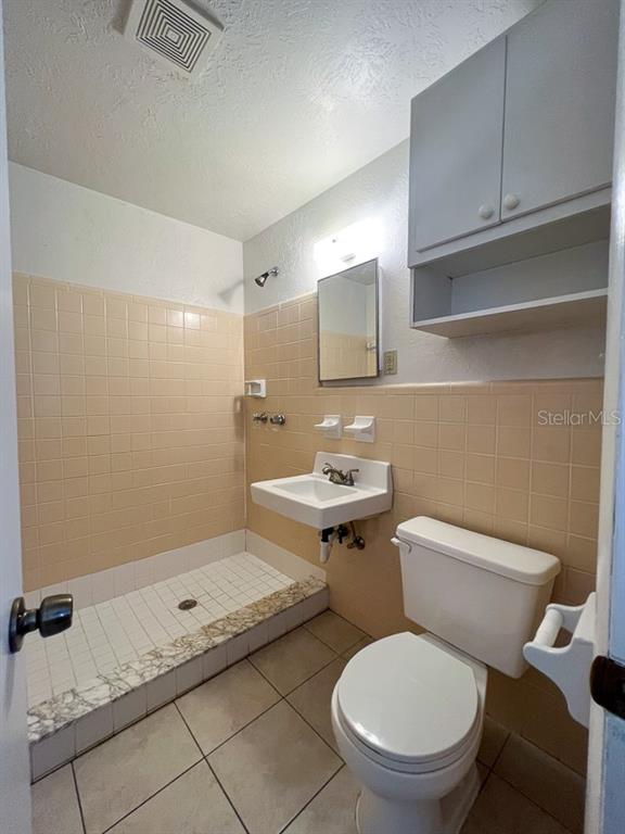 1406 Southwest 18th Place, Unit 4 Gainesville, FL 32608 - Photo 7 of 16 a bathroom with a granite countertop toilet a sink and a mirror