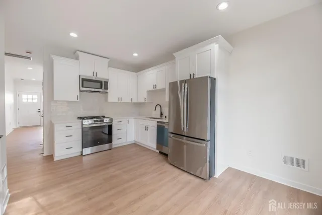 a kitchen with stainless steel appliances a refrigerator sink and microwave