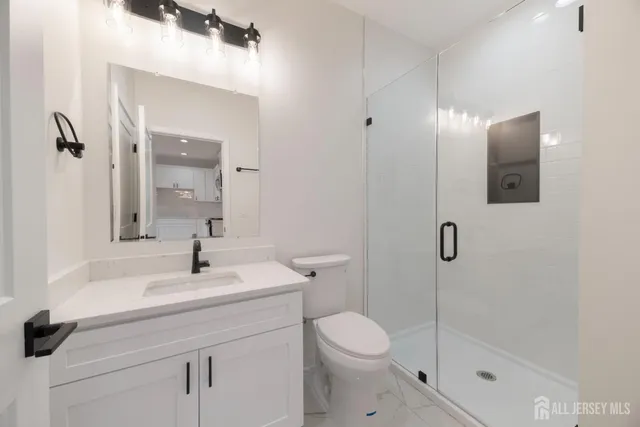 a bathroom with a sink a toilet and shower