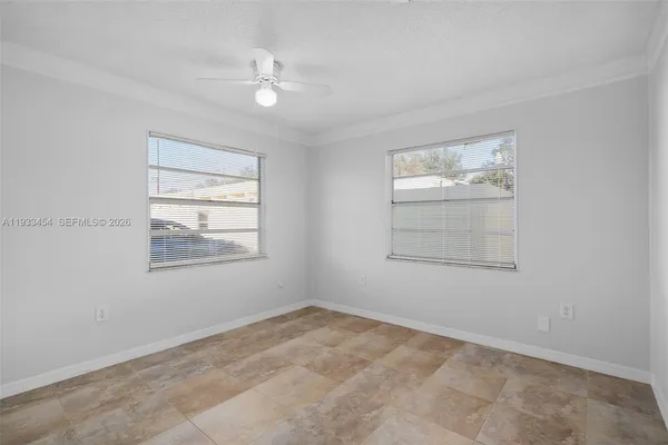an empty room with windows and ceiling fan