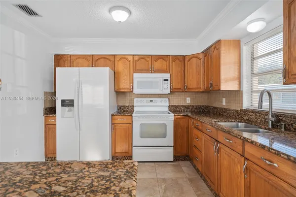 a kitchen with a refrigerator sink and cabinets