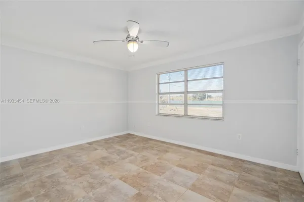 an empty room with windows and fan