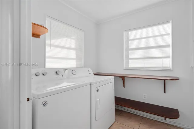 a utility room with dryer and window