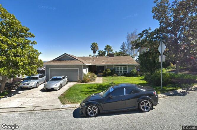 a car parked in front of a house with a yard