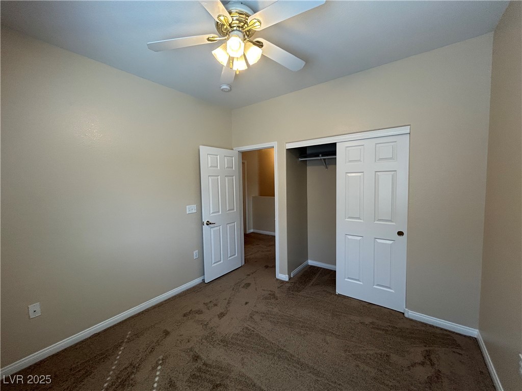 9303 Gilcrease Avenue, Unit 1131 Las Vegas, NV 89149 - Photo 20 of 36 Unfurnished bedroom with dark colored carpet, a closet, and a ceiling fan
