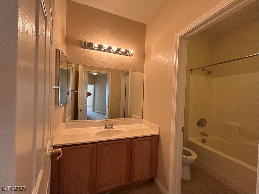 9303 Gilcrease Avenue, Unit 1131 Las Vegas, NV 89149 - Photo 25 of 36 Full bath with bathing tub / shower combination, a textured wall, vanity, and light tile patterned floors