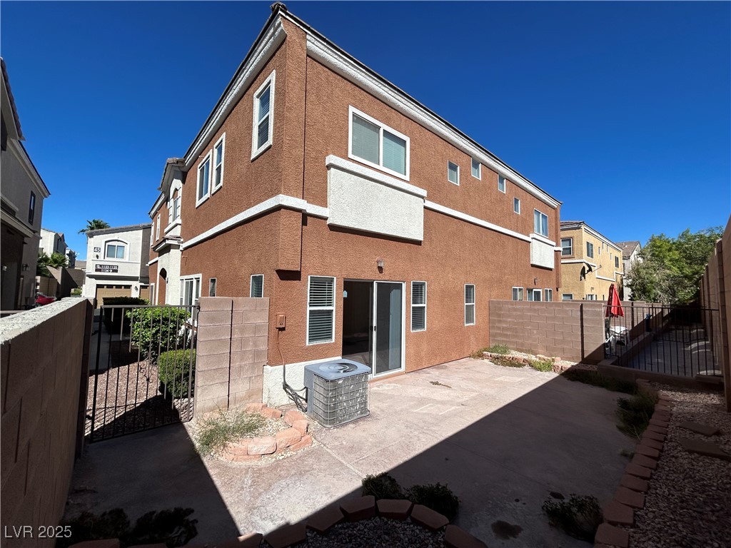 9303 Gilcrease Avenue, Unit 1131 Las Vegas, NV 89149 - Photo 30 of 36 Rear view of property featuring a gate, a fenced backyard, a patio, stucco siding, and a residential view