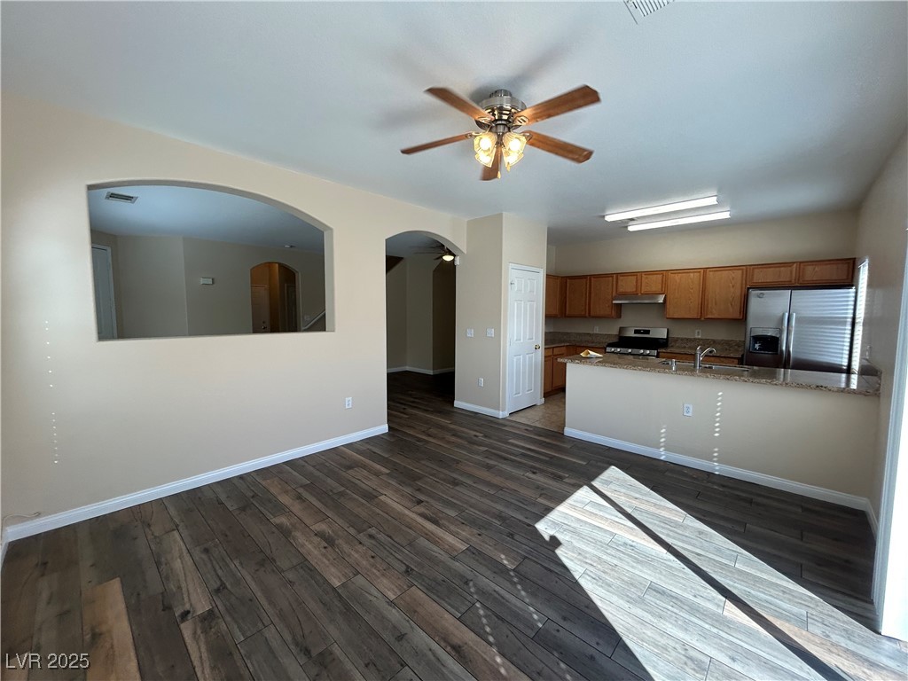 9303 Gilcrease Avenue, Unit 1131 Las Vegas, NV 89149 - Photo 34 of 36 Kitchen with appliances with stainless steel finishes, brown cabinets, open floor plan, and a ceiling fan