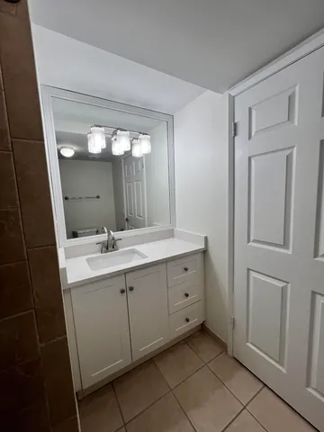 a spacious bathroom with a double vanity sink and mirror