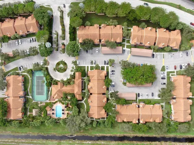 an aerial view of residential houses with outdoor space and parking