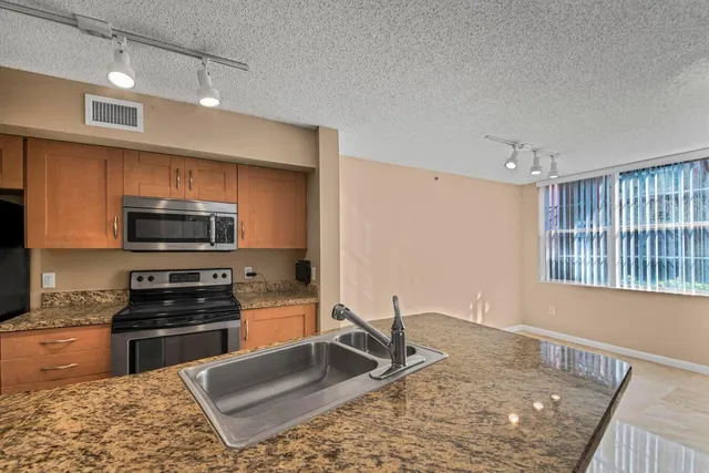 a kitchen with a sink a stove and a microwave