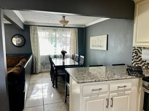 a kitchen with granite countertop a sink a stove and a microwave