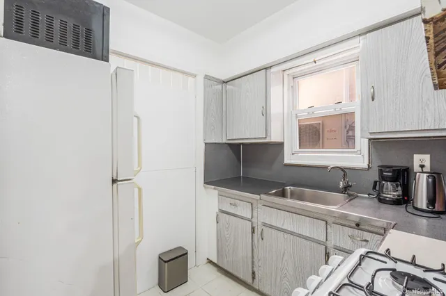 a kitchen with a sink cabinets and a window