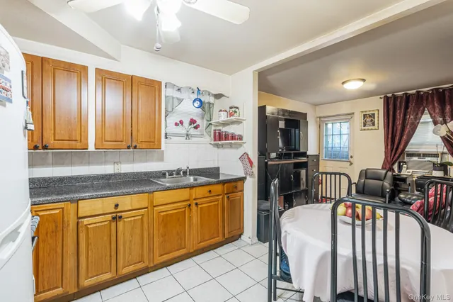 a very nice looking kitchen with granite countertop a stove a sink a dining table and chairs