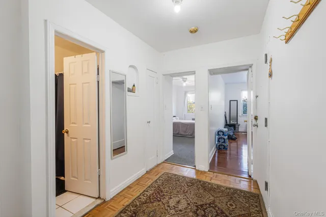 a view of a hallway with bathroom and wooden floor