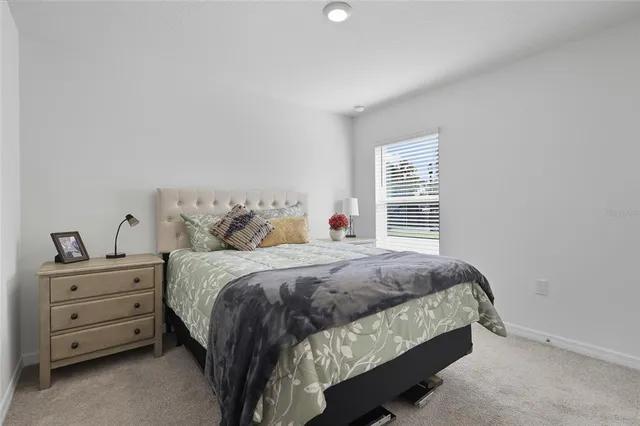 a bed sitting in a bedroom next to a window with dresser