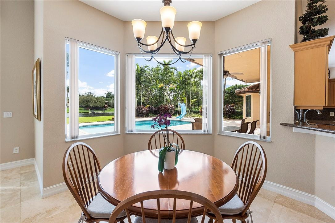 10324 Southwest 26th Street Davie, FL 33324 - Photo 12 of 37 a view of a dining room with furniture a chandelier and wooden floor